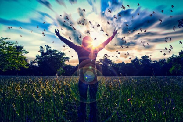 Young girl spreading hands with joy and inspiration facing the s