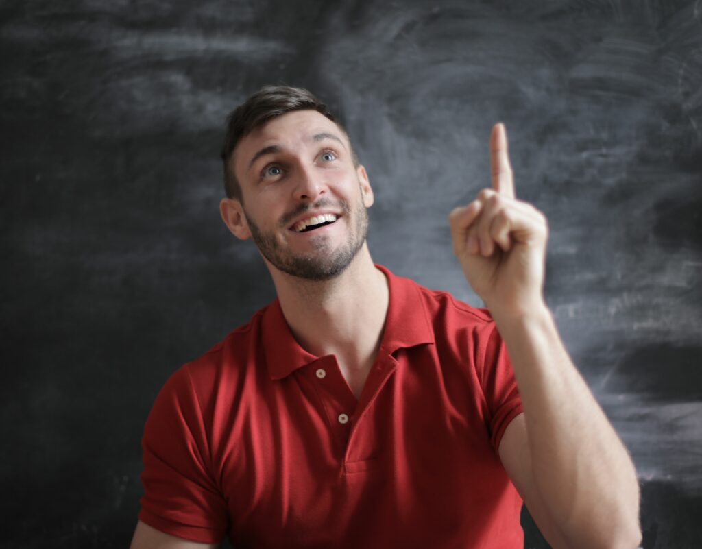 Homme souriant qui pointe vers le haut, symbole du déclic en coaching transformationnel à Colomiers