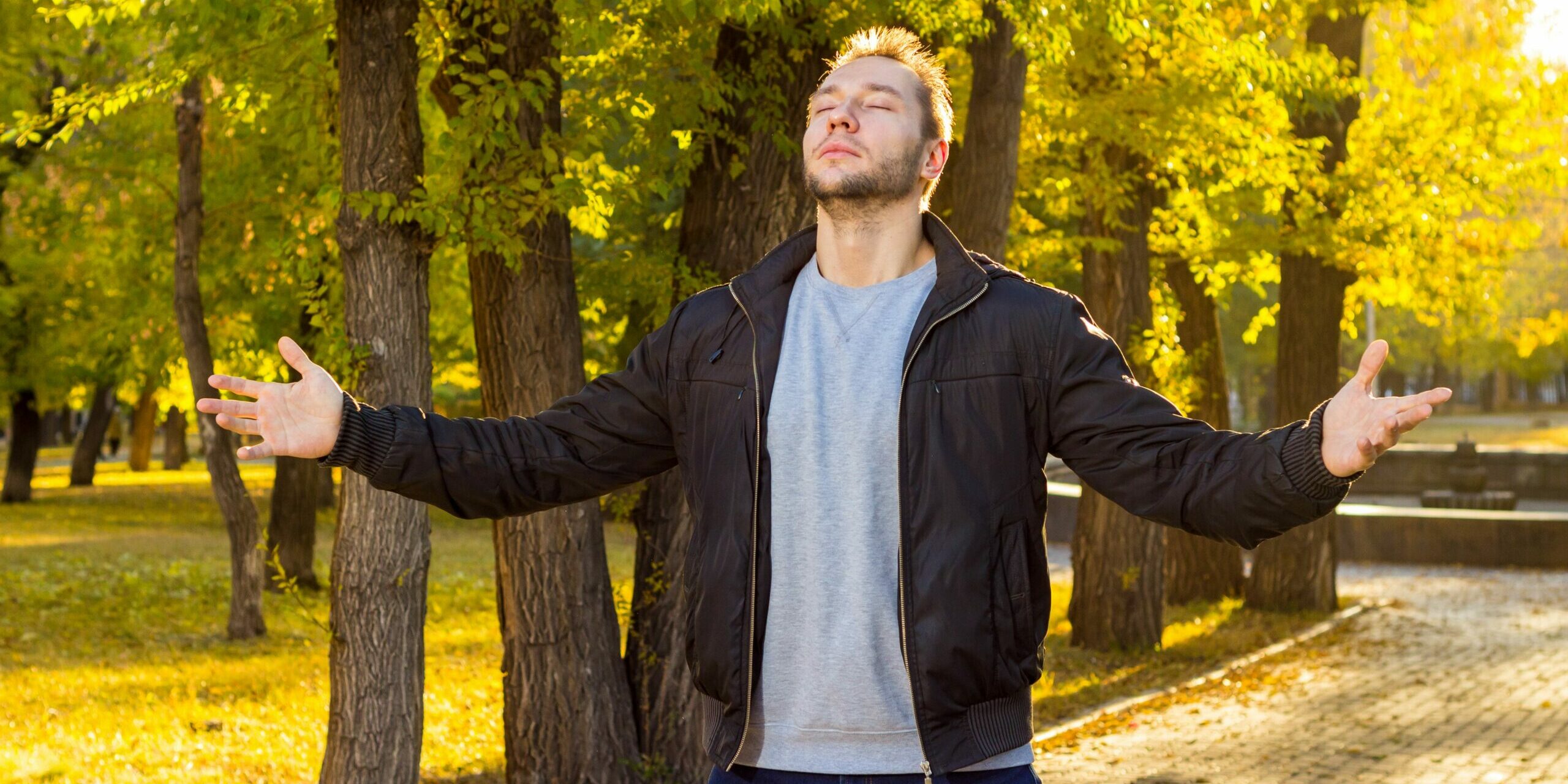 Homme les yeux fermés qui retrouve son calme dans un parc, pour apaiser une colère pour un rien grâce aux thérapies brèves.
