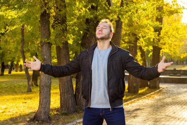 Homme les yeux fermés qui retrouve son calme dans un parc, pour apaiser une colère pour un rien grâce aux thérapies brèves.